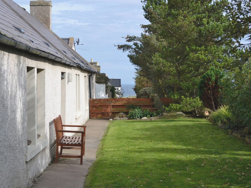 Front of cottage looking along to the sandy beach | Shelterstone, Elgin