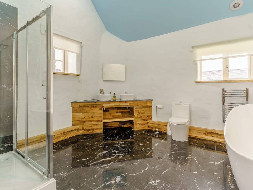 Polished stone floored bathroom | The Cowshed - Musselwick Farm, St Brides