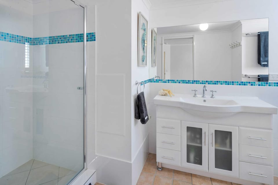 The main bathroom offers a vanity, small bath, shower and a separate toilet.