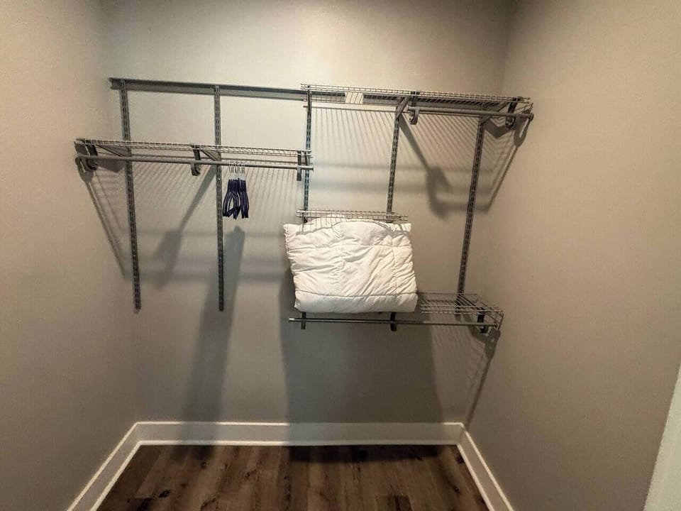 Walk-in closet: Ample shelving and hangers for effortless organization and extra linen!