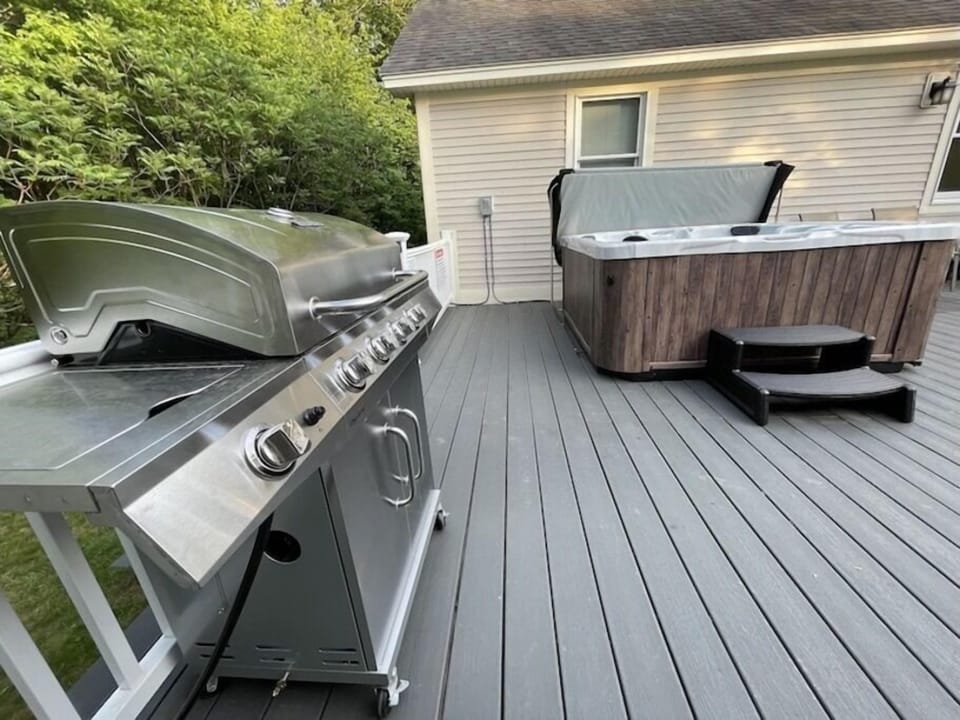 Deck with hot tub and grill// Grill is plugged into propane of home. Never run