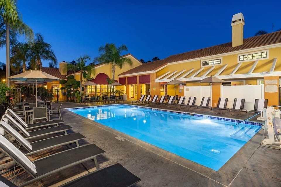 Unwind under evening lights in a resort-style swimming pool.