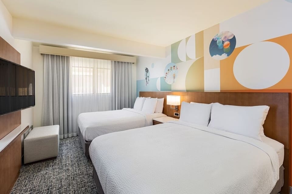 Unwind in bright twin-queen comfort with playful mural accents.