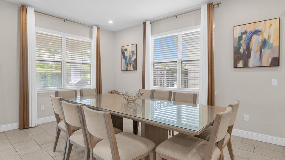 Spacious dining area with elegant glass-top table, perfect for family gatherings and entertaining.