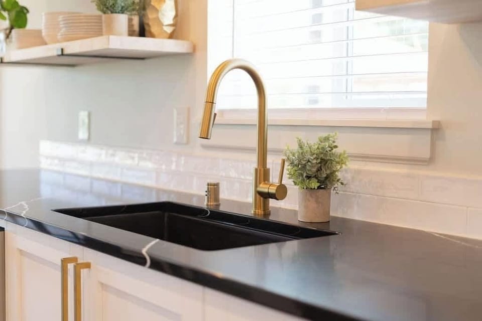 The kitchen features polished bronze hardware and accents, adding elegance and warmth. These gleaming details enhance the kitchen's modern design and overall aesthetic.