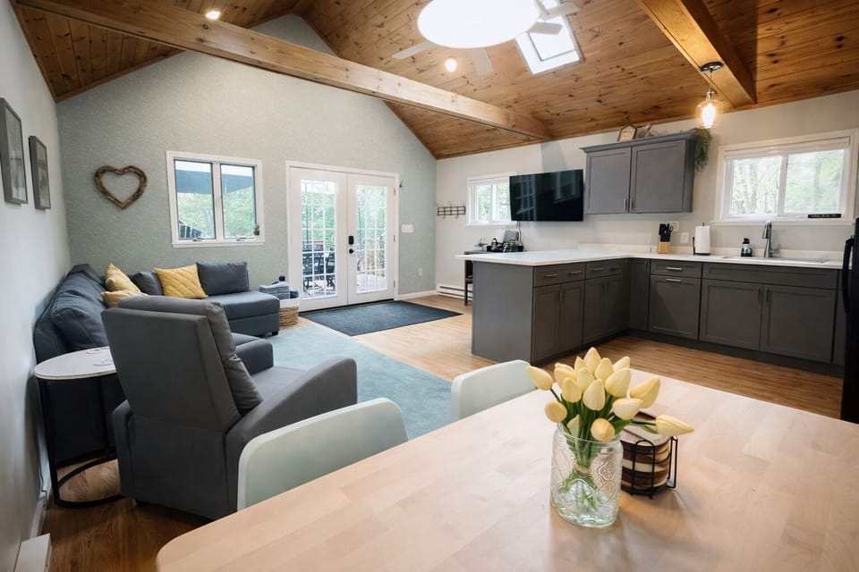 Open-concept with vaulted wood ceilings, cozy seating and fully equipped kitchen