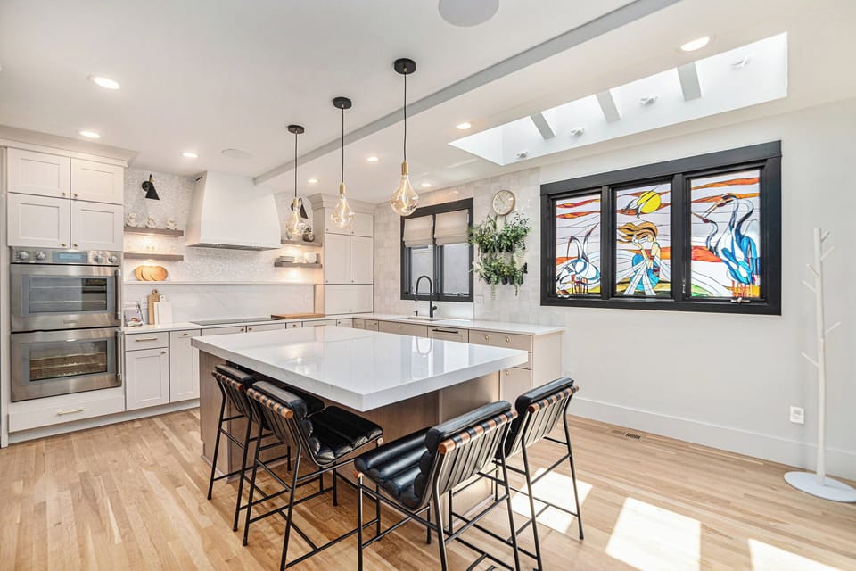 - Enjoy this chef inspired kitchen with quartz counters, pendant lights, and top tier appliances
- Island seating for four makes it ideal for morning coffee or casual meals
- Artistic stained glass window adds a vibrant personal touch