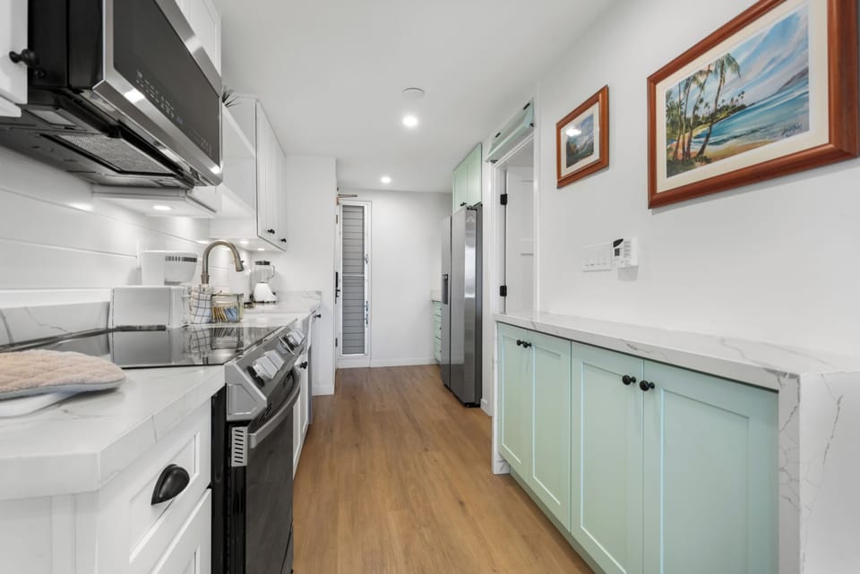Your bright, modern kitchen blends coastal charm with every convenience—crisp white cabinets, soft mint accents, and sleek appliances await your culinary adventures.