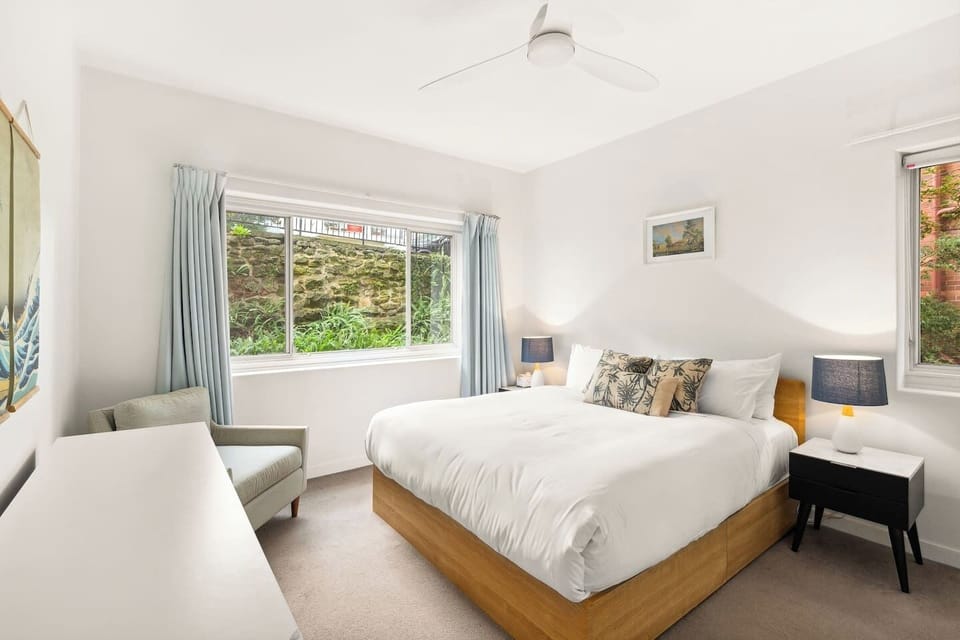 Bid goodnight to nature from the primary bedroom featuring a plush king-sized bed. 

