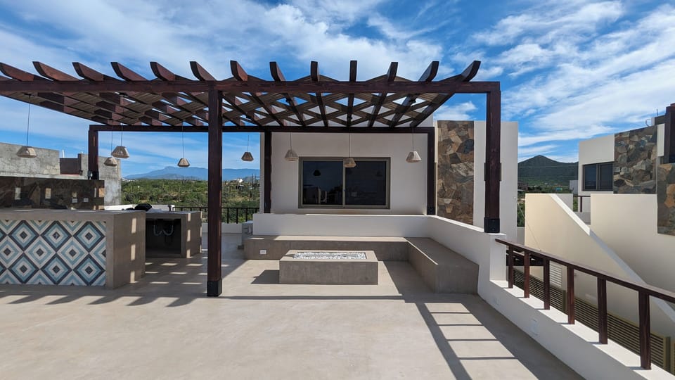 Rooftop patio with BBQ island, pergola shading, seating area and fire pit