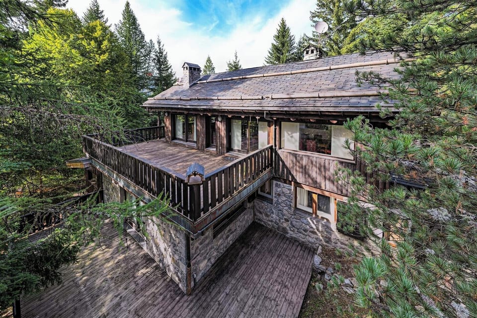 Experience the charm of this rustic cabin nestled in the woods. The spacious deck offers a perfect spot for outdoor dining and relaxation, surrounded by serene beauty of the forest.