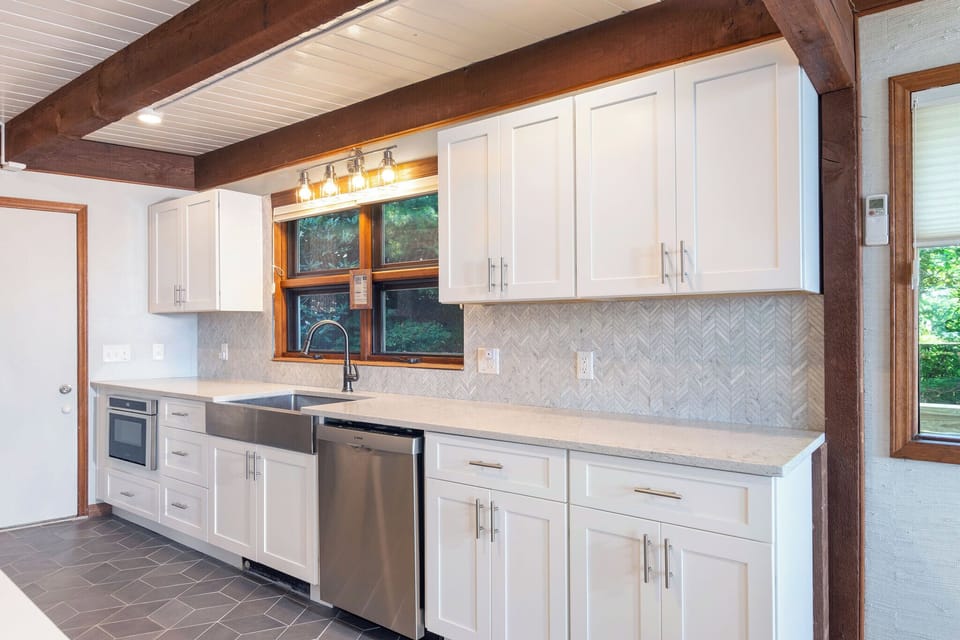 Kitchen with stainless appliances, dishwasher, Keurig and drip-style coffee pot, and access to the garage.