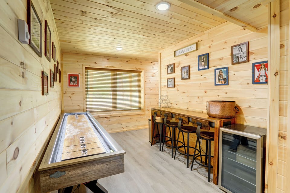 Part of the basement game area including shuffleboard and a wine cooler.