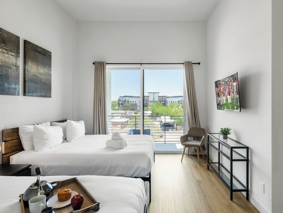 Unit 2 (2nd Floor): Primary Bedroom featuring 2 Queen Beds, a Smart TV, a private balcony, and an ensuite primary bathroom.