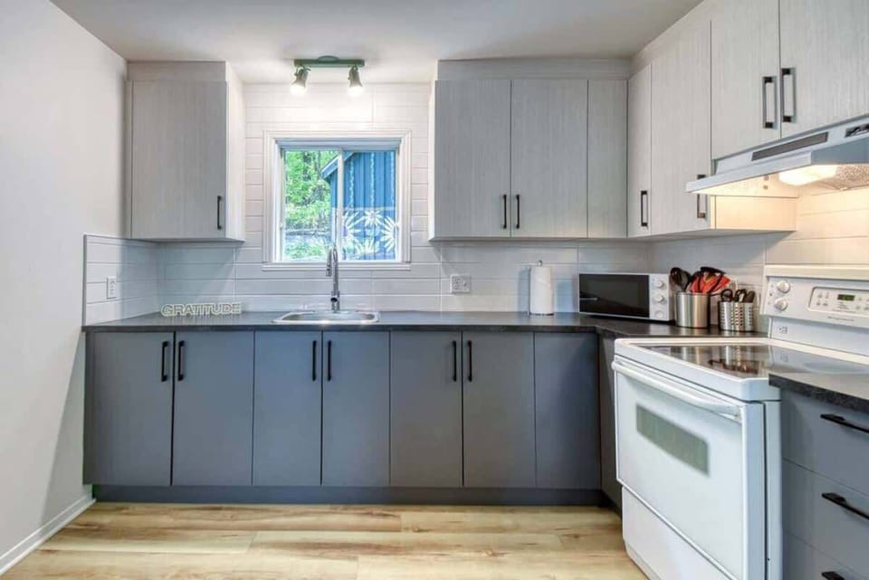 Modern grey and white kitchen featuring sleek finishes and all the essentials for home-cooked meals in style.