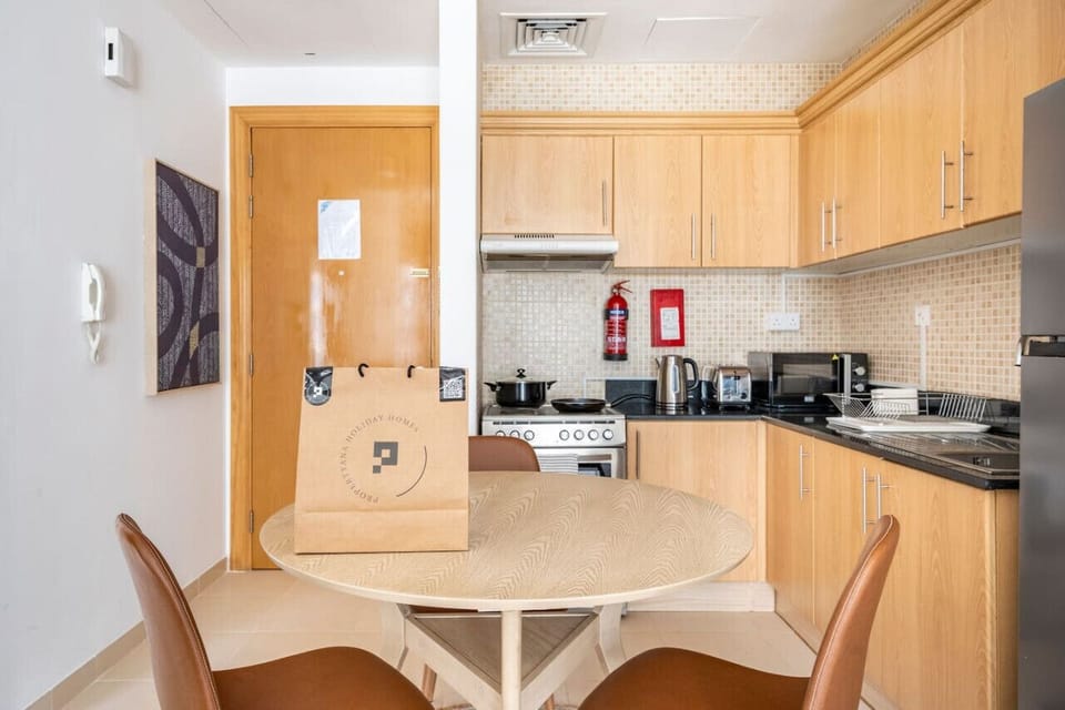 Cozy dining area and modern kitchen in a one-bedroom apartment in the Mayfair Building, Business Bay. Perfect for a holiday home in Dubai, vacation rental in Dubai, short-term rental in Dubai, or monthly rental in Dubai, featuring essential appliances and
