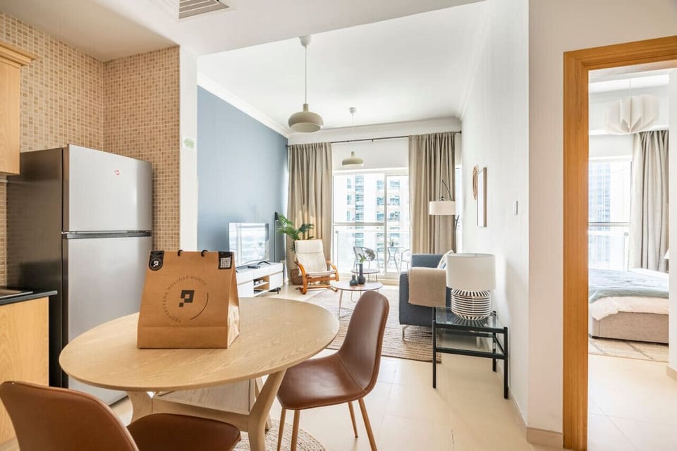 Cozy dining area and modern kitchen in a one-bedroom apartment in the Mayfair Building, Business Bay. Perfect for a holiday home in Dubai, vacation rental in Dubai, short-term rental in Dubai, or monthly rental in Dubai, featuring essential appliances and