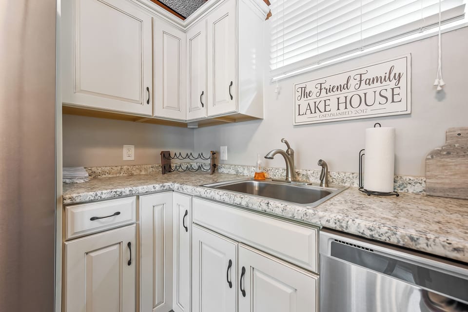 Bright and cozy kitchen with granite countertops and a personalized lake house touch.