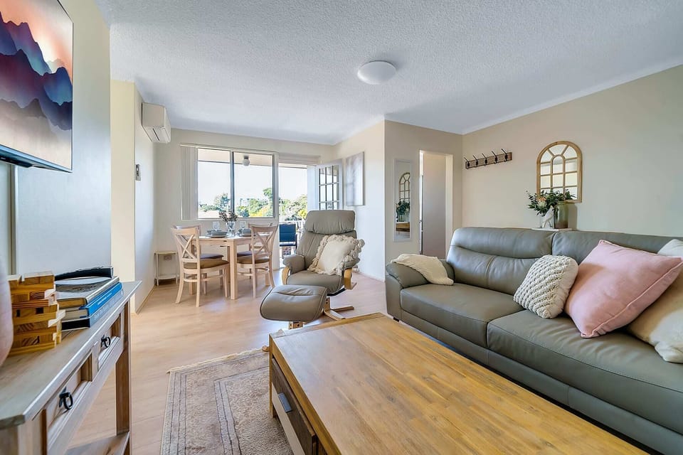 Relax on our grey couch, gather around the wooden lounge table, and enjoy your favourite shows on TV.