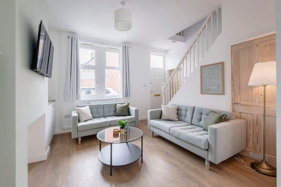 A clean, relaxing space — unwind in the spacious living room with a plush sofa set and a smart TV for the ultimate comfort and entertainment.