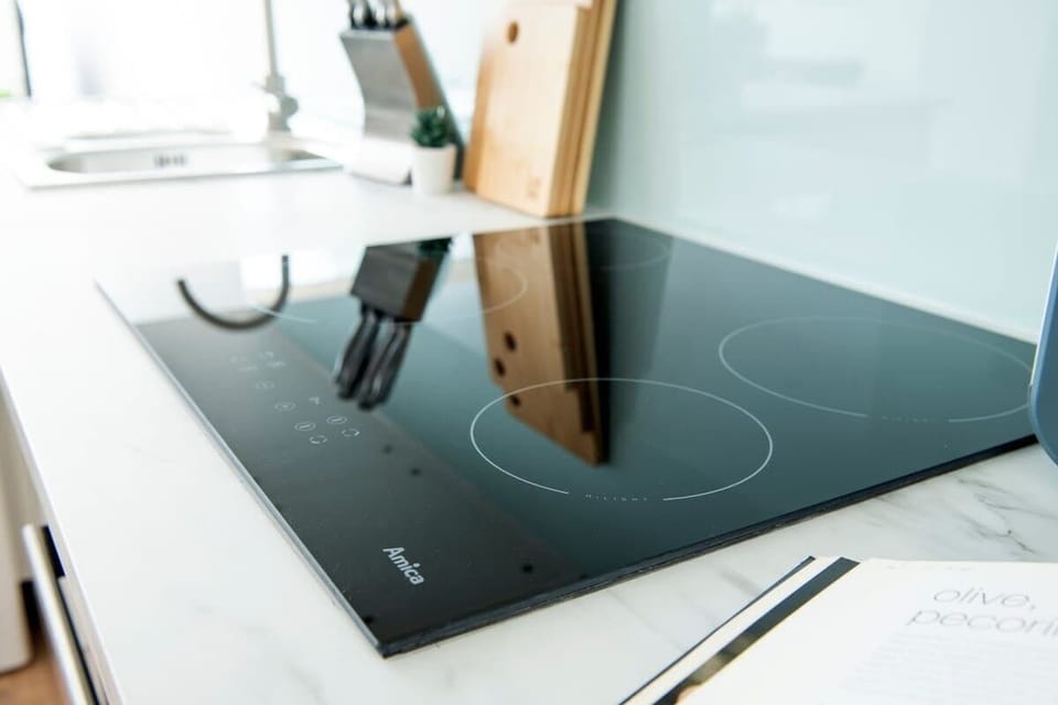 Minimalist and spotless — a clean kitchen area with sleek essentials and a convenient washing machine for a fuss-free stay.