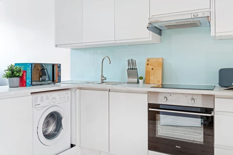 "A small yet sleek and minimalist kitchen, designed for both efficiency and style—perfect for preparing meals in a modern, clutter-free space."