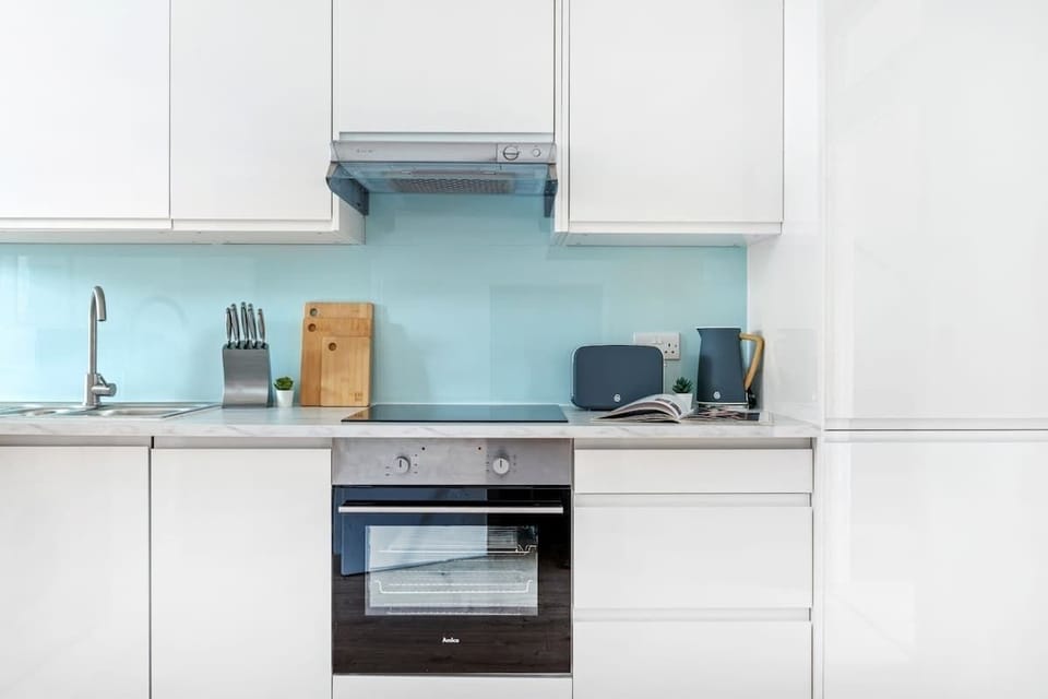 "A small yet sleek and minimalist kitchen, designed for both efficiency and style—perfect for preparing meals in a modern, clutter-free space."