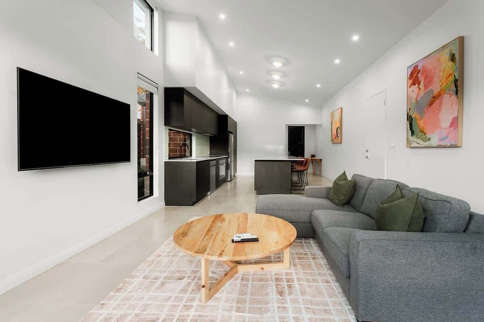 The open-plan design seamlessly connects the living, kitchen and dining zones, creating a bright social space where conversation flows easily from morning coffee to evening drinks.