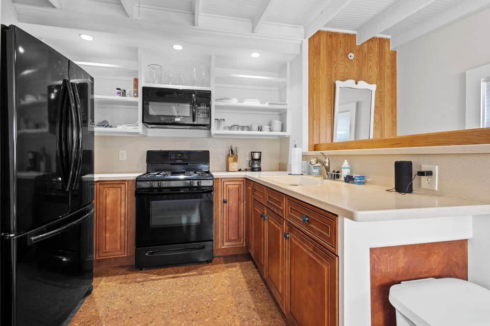 The kitchen features a double sink, gas stove and oven, microwave, and a French-door refrigerator.
