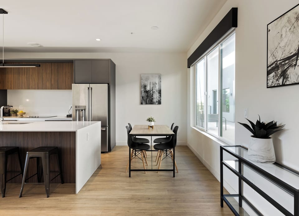 1st Floor: Fully equipped modern kitchen featuring culinary essentials, stainless steel appliances, island bar seating, and a dining area.