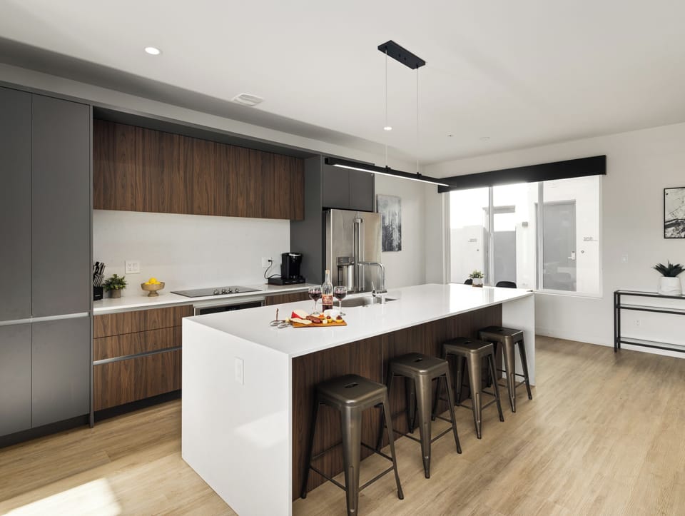 1st Floor: Fully equipped modern kitchen featuring culinary essentials, stainless steel appliances, island bar seating, and a dining area.