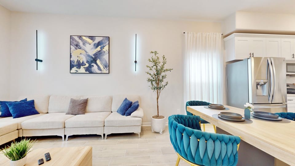 Cozy living room with comfy chairs, modern table, and fridge. 