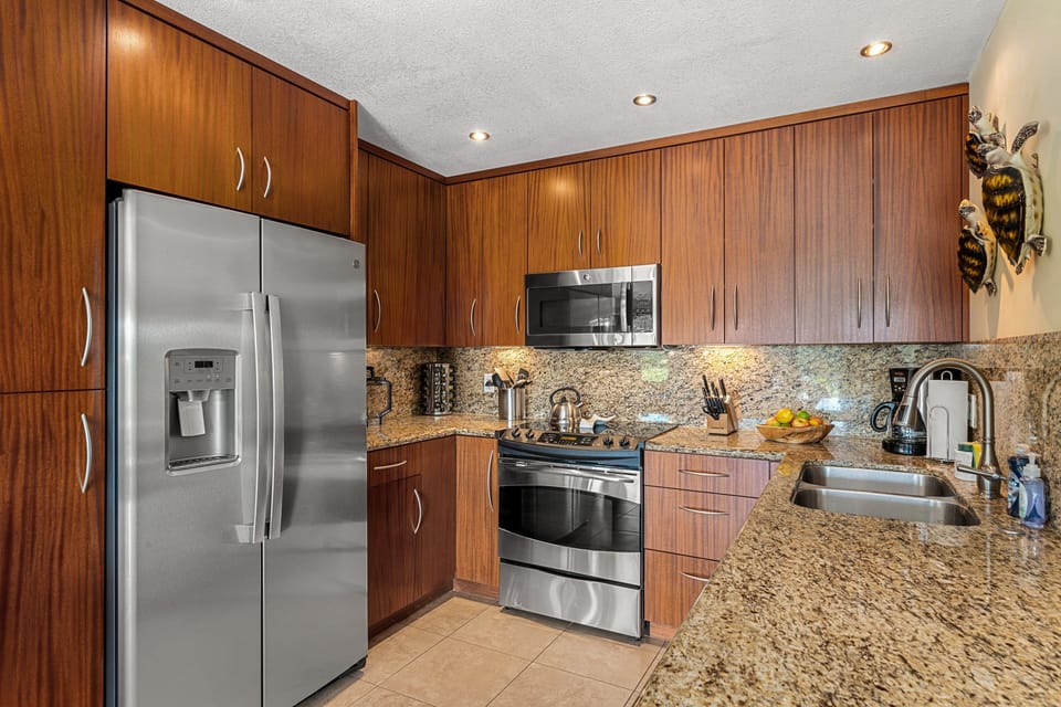 Cook in style with a fully equipped kitchen featuring granite countertops, stainless steel appliances, and tropical decor, perfect for preparing family meals in paradise.
