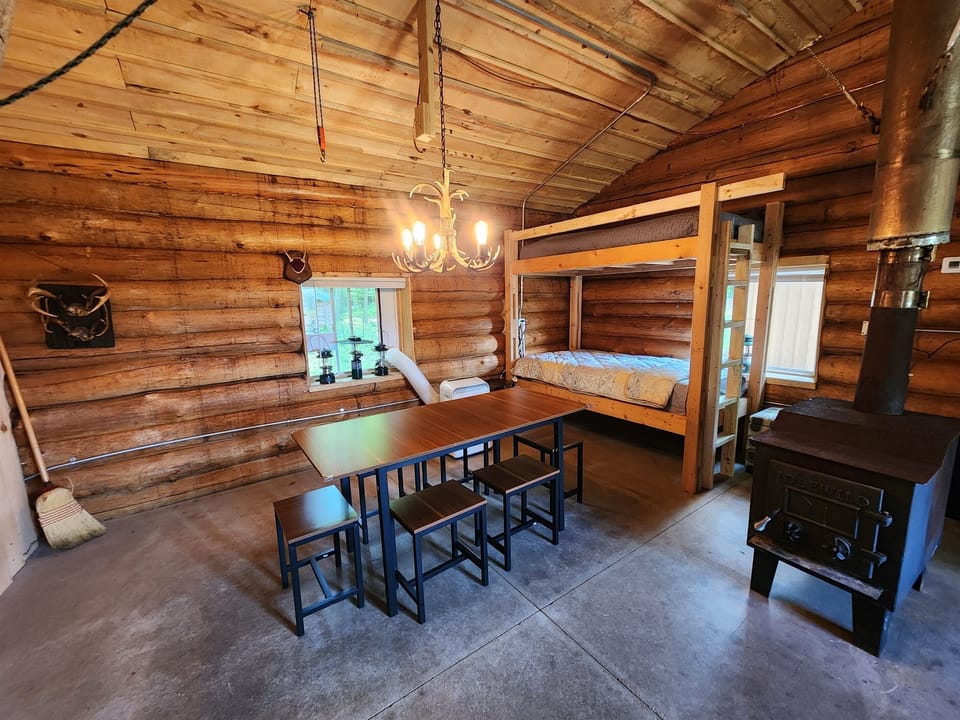 2nd sleeping cabin with table, couch, TV and 2 sets of bunk beds