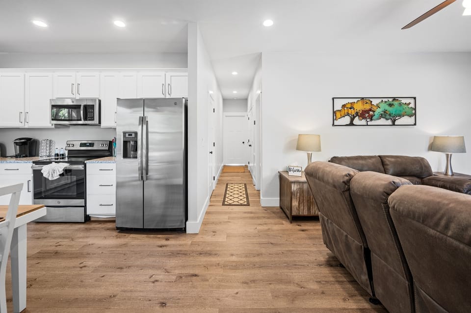 Open living space with full kitchen, dining, and seating all connected—designed so everyone can gather comfortably without feeling cramped. Clean, modern layout makes meals, movie nights, and group time easy and relaxed.