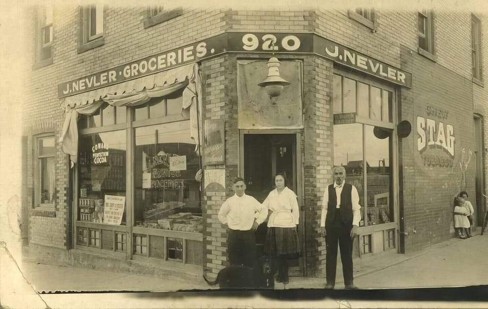 Historical photo of the original building in 1915 with owner J. Nevler