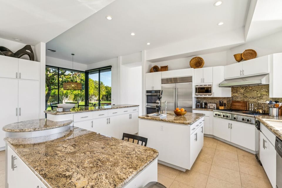Bright kitchen w/ large island, bar seating & wide windows bringing in natural light