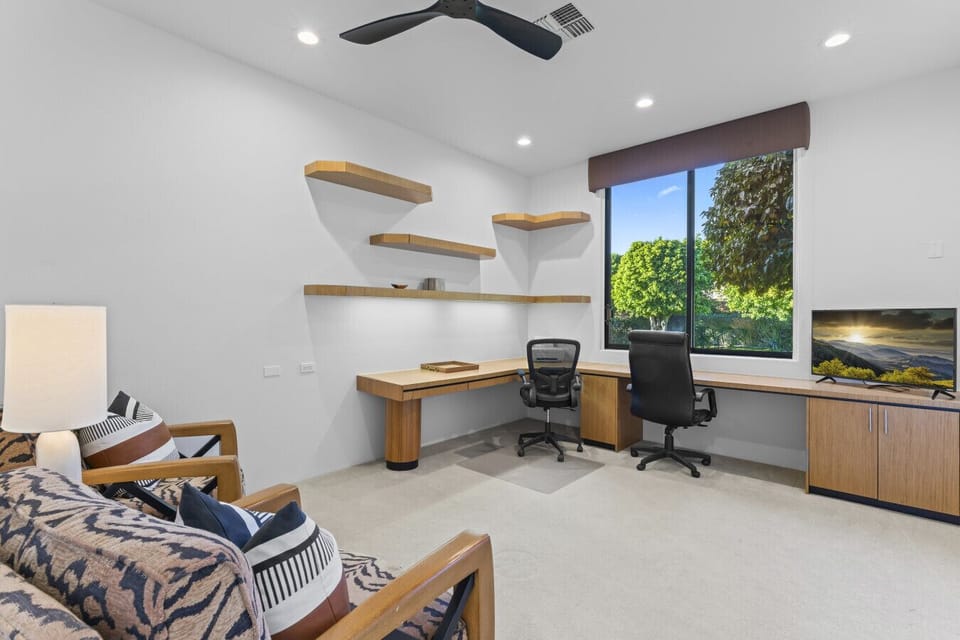 Bright workspace w/ desk setup, wall shelving & large window for natural light