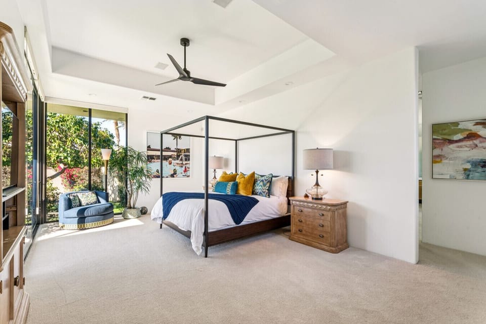 Serene bedroom w/ canopy bed, high ceilings & sliding doors opening to the garden