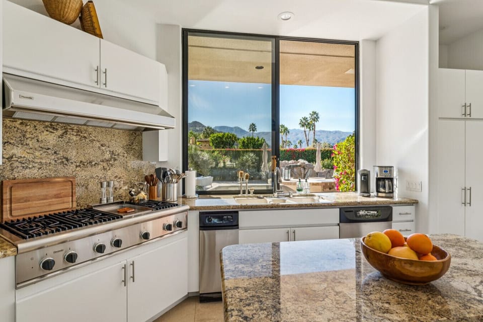 Gourmet kitchen w/ stone backsplash, pro range & window framing scenic views