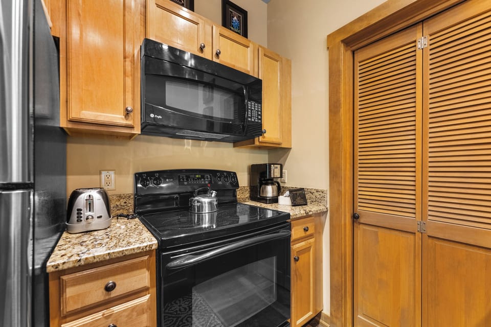 Full kitchen with breakfast bar, new appliances, and coffee maker.