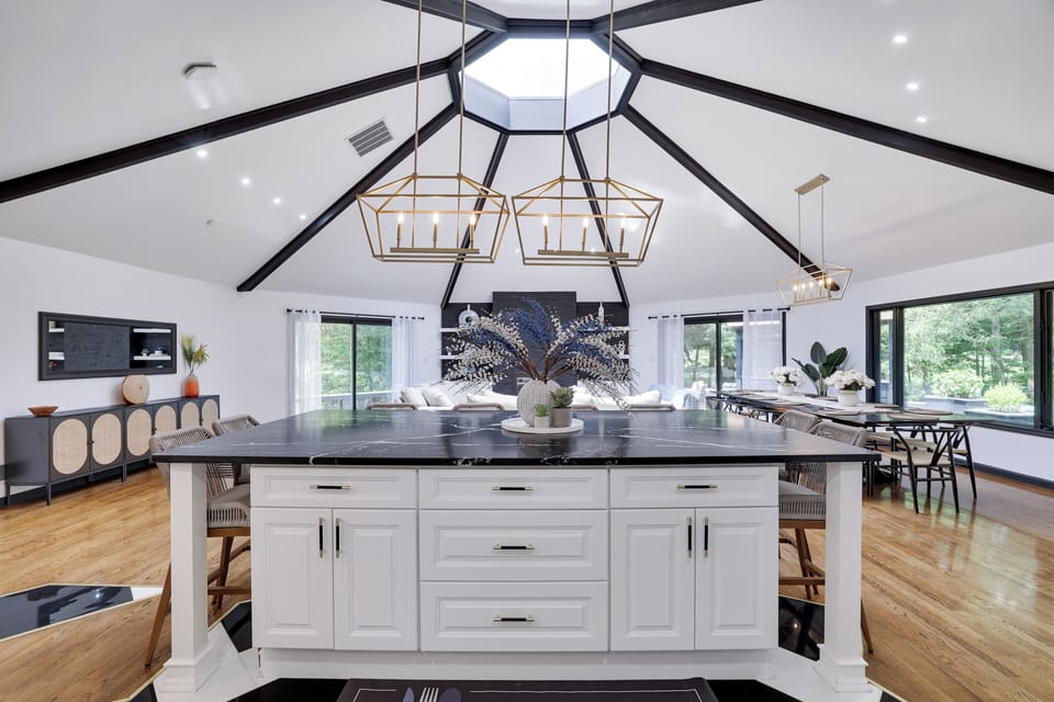 Bright open space with marble island, gold lights, and vaulted elegance.
