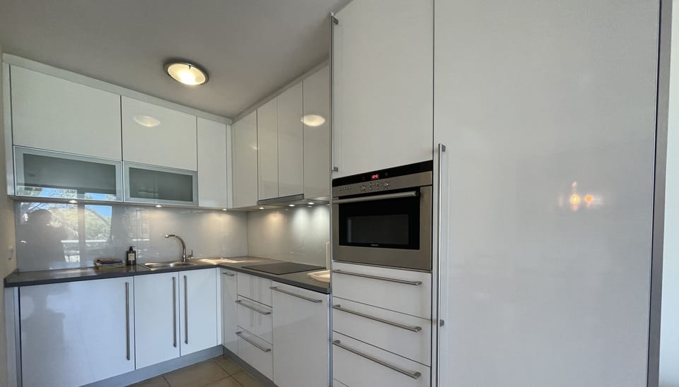 Modern, fully equipped kitchen with integrated appliances and bright countertop lighting.