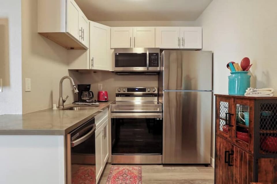 Dishwasher, glass-top electric stove, fridge, microwave, and coffee maker.