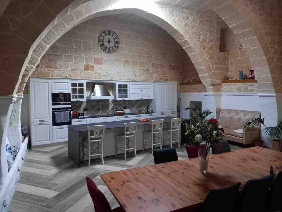 Large modern kitchen area with central island, open plan plus dining area overlooking the pool.