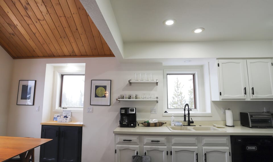 - Kitchen essentials include drip and pod coffee maker, mugs, and glassware - Sink sits under a bright window for dish duty with a view of the treetops - Simple layout makes mornings smooth and clean up easy for all