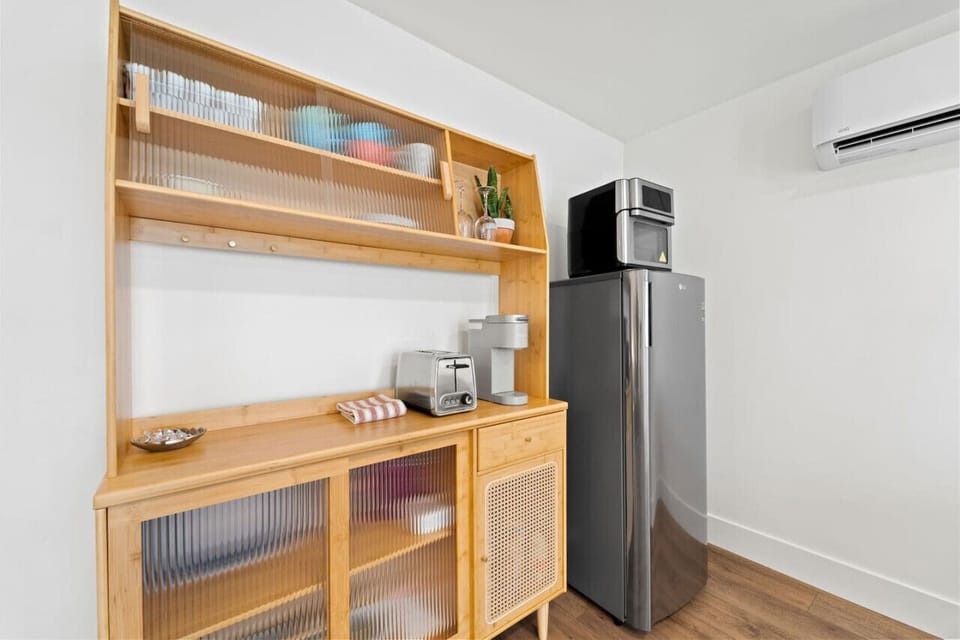 Open kitchen shelving w/ wood accents, bar seating & modern appliances for easy meals at home.