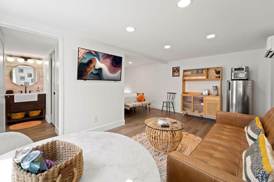 Open-concept living space w/ comfy seating, wood floors & seamless flow into the kitchen.