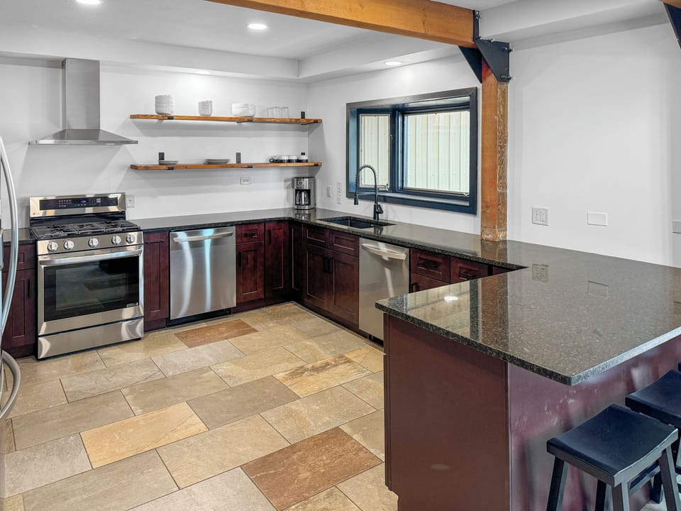 Remodeled kitchen has gas range and hood. Two dishwashers and bar seating for 3.