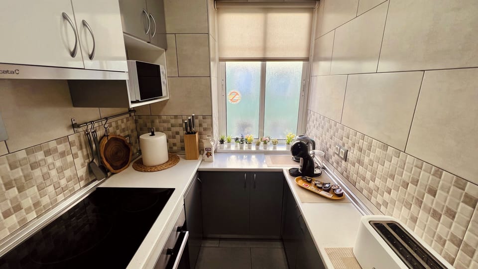 Bright, modern galley kitchen with coffee station and natural light